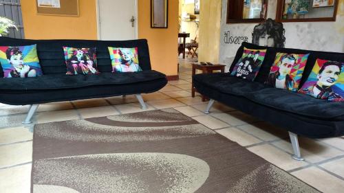a living room with two black couches with pillows at Leo's Clan Beach Hostel in Paraty