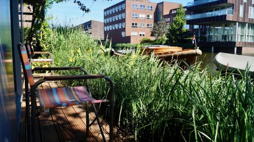 a chair sitting next to a body of water with boats at Room With A Few in Amsterdam