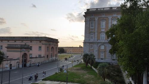 a street with two buildings and people walking down a street at L'Insolita Reggia in Caserta