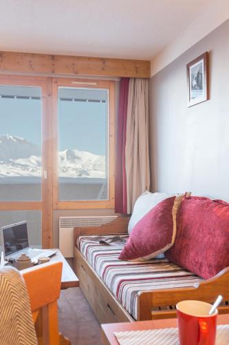 une chambre avec un lit et un bureau avec un ordinateur portable dans l'établissement Résidence Pierre & Vacances Les Constellations, à Belle Plagne