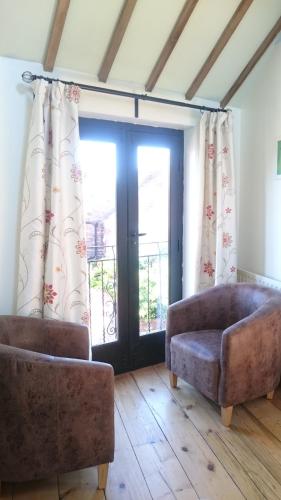 a living room with two chairs and a couch at The Stables in Southwell in Southwell