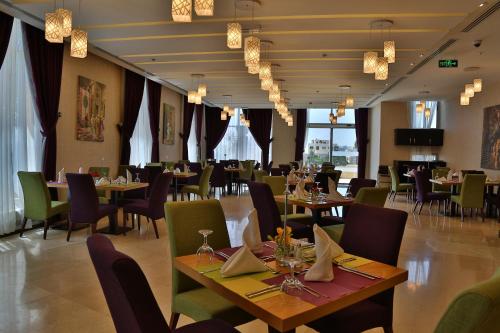 a dining room with tables and chairs and tablesearcher at Olive Tree Amman in Amman