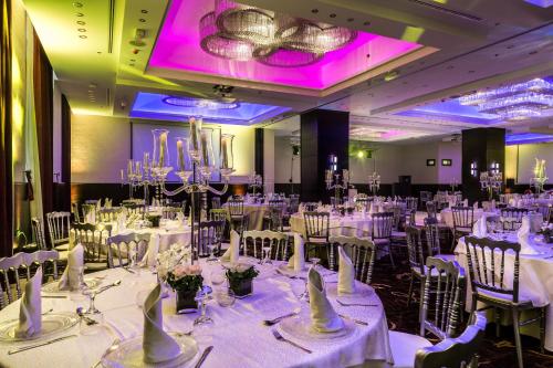 a banquet hall with white tables and chairs at Olive Tree Amman in Amman