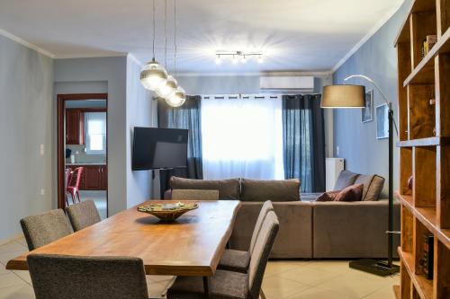 una sala de estar con una mesa y un sofá en Meteora View Modern Apartments, en Kalambaka