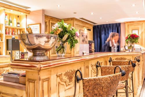 - un bar avec un comptoir agrémenté de chaises et de fleurs dans l'établissement Villa Alessandra, à Paris