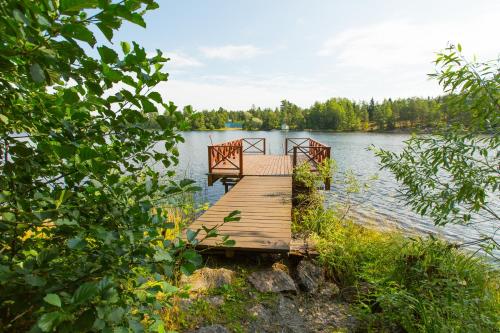 ein Holzsteg in der Mitte eines Sees in der Unterkunft Holiday Park Lesnaya Skazka in Wyborg