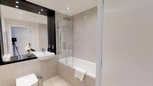 a bathroom with a shower and a sink and a tub at Signet Apartments - Vesta in Cambridge