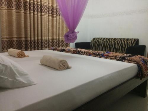 a bed with two pillows on it in a room at Mountain Villa Adam's Peak in Adams Peak