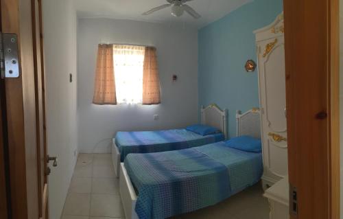 - 2 lits dans une petite chambre avec fenêtre dans l'établissement Ix Xaluppa J6 Apartment, à Għajnsielem