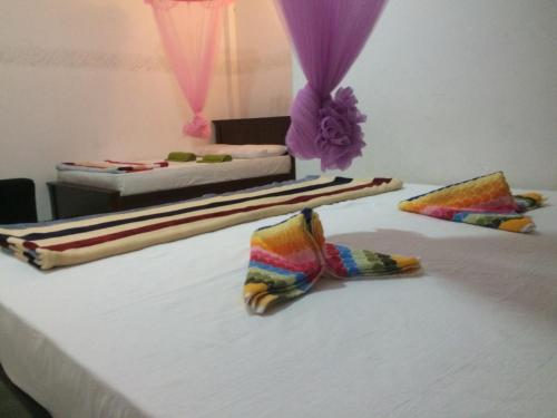 two beds in a room with towels on a bed at Mountain Villa Adam's Peak in Adams Peak