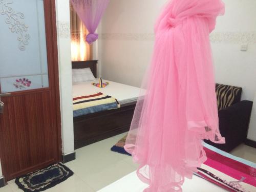 a pink dress hanging in a room with a bed at Mountain Villa Adam's Peak in Adams Peak
