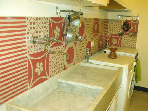a kitchen with red and white patterns on the wall at Americhe Apartment in Sestri Levante