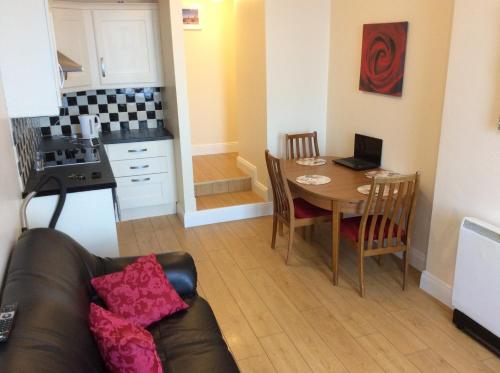 a living room with a table and a kitchen at Wexford Town Opera Mews - 1 Bed Apartment in Wexford