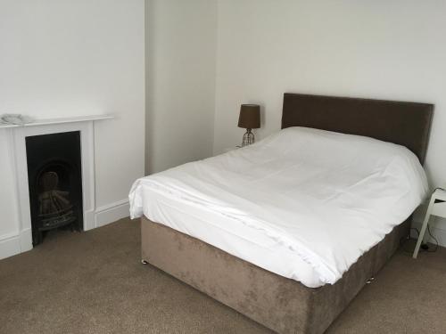 a bedroom with a bed and a fireplace at Cambridge Water House Apartments in Cambridge