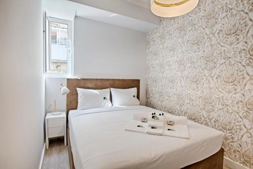 リスボンにあるBmyGuest - Ambassador Boutique Apartment IIのベッドルーム1室(白いベッド1台、キャンドル2本付)