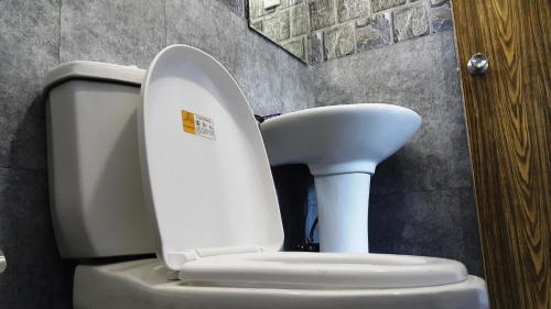 a white toilet with the lid up in a bathroom at Green Garden Guest Mirissa in Mirissa