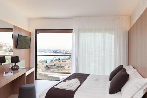 sypialnia z łóżkiem i dużym oknem w obiekcie Eolian Milazzo Hotel w mieście Milazzo