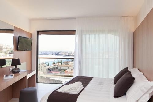 a bedroom with a bed and a large window at Eolian Milazzo Hotel in Milazzo