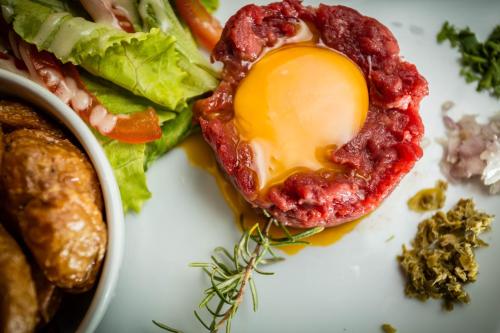 a plate of food with an egg and lettuce at Auberge du Bon Vivant in Argelès-sur-Mer