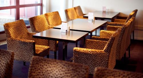 a row of tables and chairs in a restaurant at Home Hotel Arcticus in Harstad