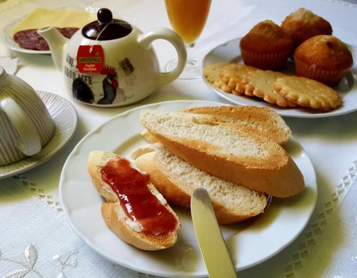 a table with plates of bread and jam and cupcakes at Posada Las Garzas in Santoña