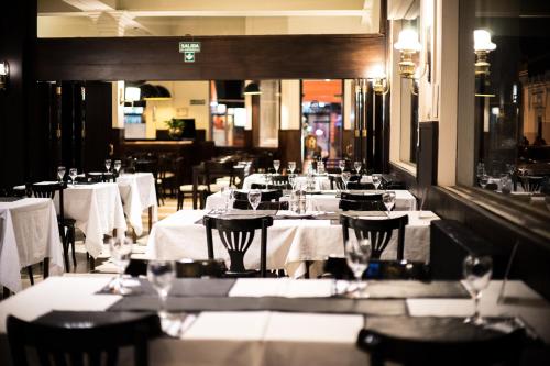 a restaurant with tables and chairs with white table cloth at Hotel Viña de Italia in Cordoba