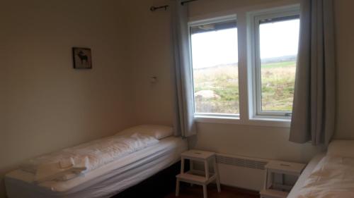 une chambre avec deux lits et une fenêtre dans l'établissement Hjartarstaðir Guesthouse, à Eiðar