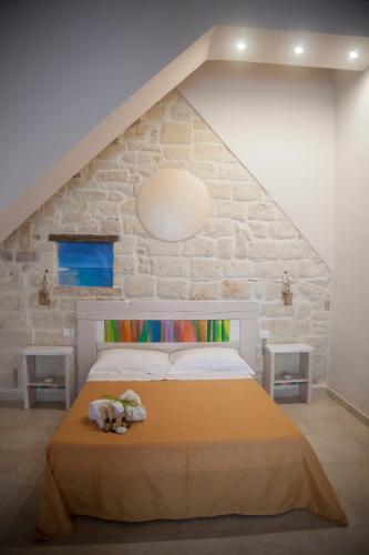 a bed in a room with a stone wall at 3 Archi B&B in Trani