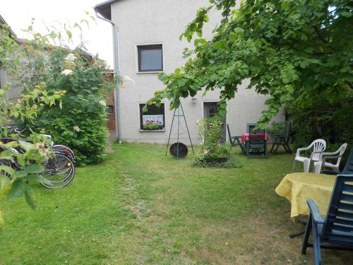 einen Garten mit einem Tisch und Stühlen sowie einem Gebäude in der Unterkunft Ferienwohnungen Ute Simdorn in Görke