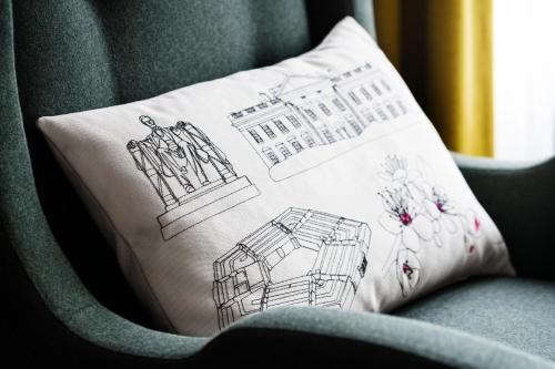 a pillow with a building on it sitting on a chair at The Darcy Hotel, Washington DC in Washington
