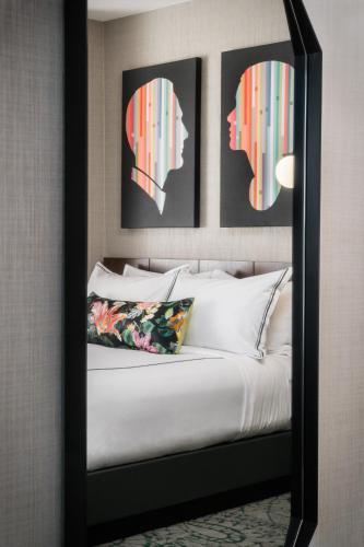 a bedroom with a large mirror above a bed at The Darcy Hotel, Washington DC in Washington
