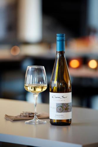 a bottle of white wine next to a glass at Home Hotel Magasinet in Trelleborg