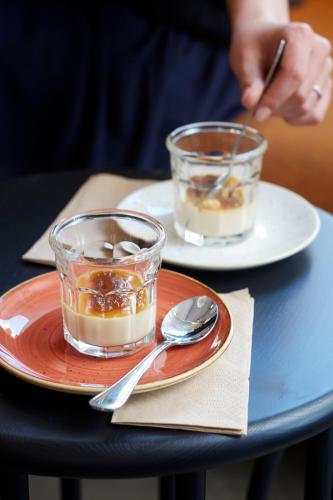 two plates of food on a table with two glasses of dessert at Home Hotel Magasinet in Trelleborg