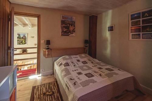 a small bedroom with a bed and a window at Gîte " Orée des bois" in Vertolaye