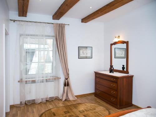 a bedroom with a dresser and a mirror and a window at Skapas Street Vilnius in Vilnius