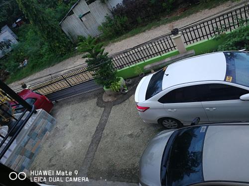 two cars parked in a parking lot next to a fence at A's Azotea de Bohol in Tagbilaran City