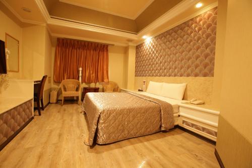 a hotel room with a bed and a table at Hua Yue Hotel in Taoyuan
