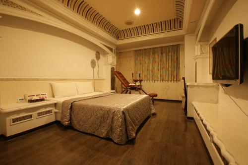 1 dormitorio con 1 cama y TV. en Hua Yue Hotel en Taoyuan