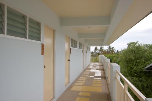 a corridor of a building with white walls and a sidewalk at Charn Residence in Bangsaen