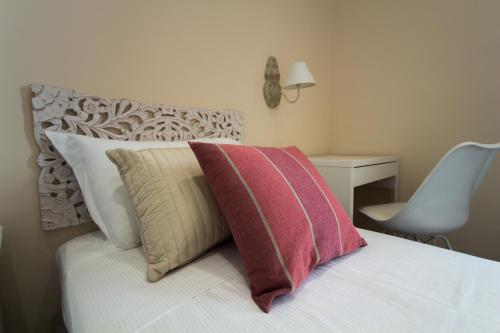 a bedroom with a bed with pillows and a desk at Emily Rooms in Sanremo