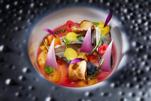 a bowl of soup with vegetables on a metal surface at Occidental Faro in Faro