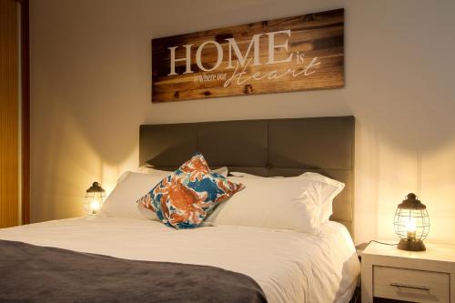 ein Schlafzimmer mit einem Bett mit einem Schild, auf dem die Heimbesserung steht in der Unterkunft Peace Haven in Calheta