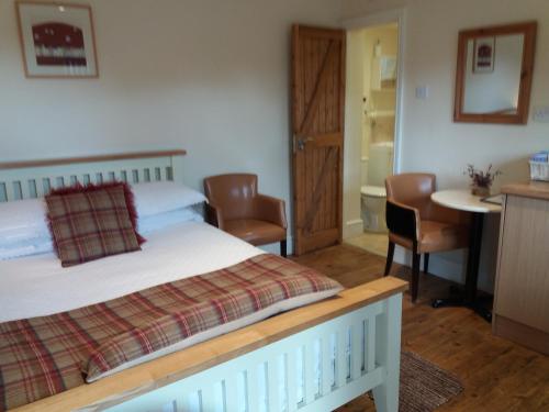 a bedroom with a bed and a table and chairs at The Stables - Deer Park Farm in Solihull