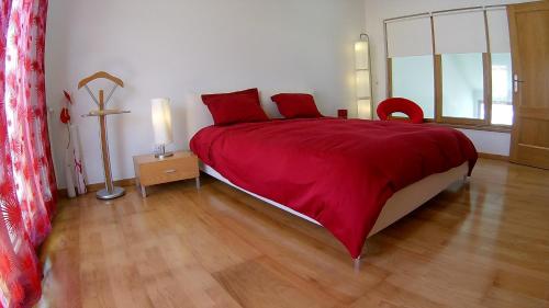 ナザレにあるCasa da Buzinaのベッドルーム1室(赤毛布付きの大型ベッド1台付)