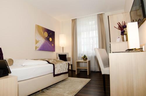 a hotel room with a bed and a window at Hotel Merkur - Superior in Baden-Baden