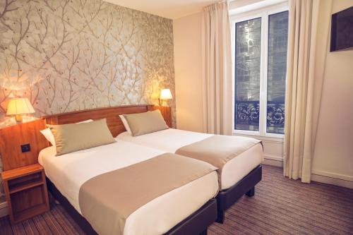 une chambre d'hôtel avec deux lits et une fenêtre dans l'établissement Timhotel Le Louvre, à Paris