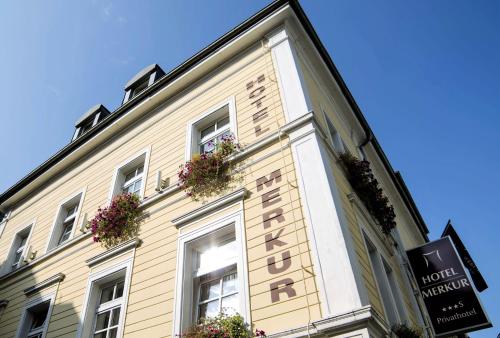 a building with flowers on the side of it at Hotel Merkur - Superior in Baden-Baden
