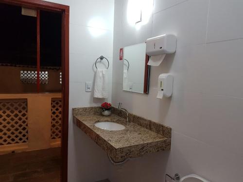 uma casa de banho com um lavatório e um espelho em Hostel Casa de Avany em Cachoeira