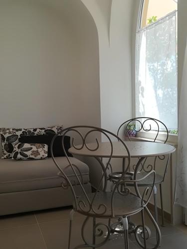 a table and two chairs in a room with a couch at Il Covo delle Civette in Vietri sul Mare
