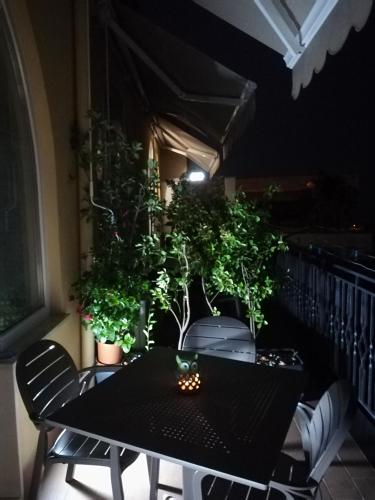 a black table and chairs on a balcony with plants at Il Covo delle Civette in Vietri sul Mare